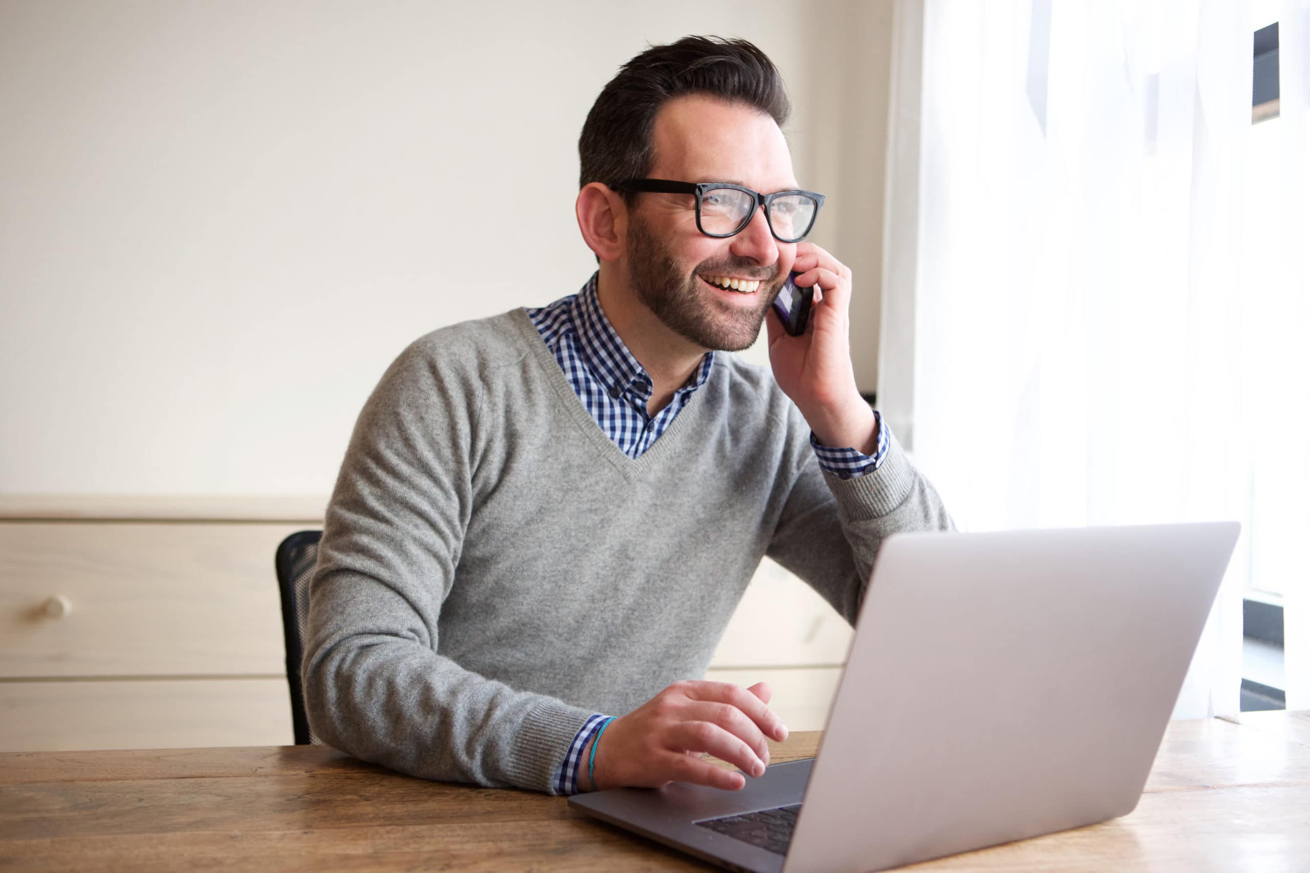 Effective Warm Calling for Lead Generation Man making warm call on phone for lead generation with laptop.