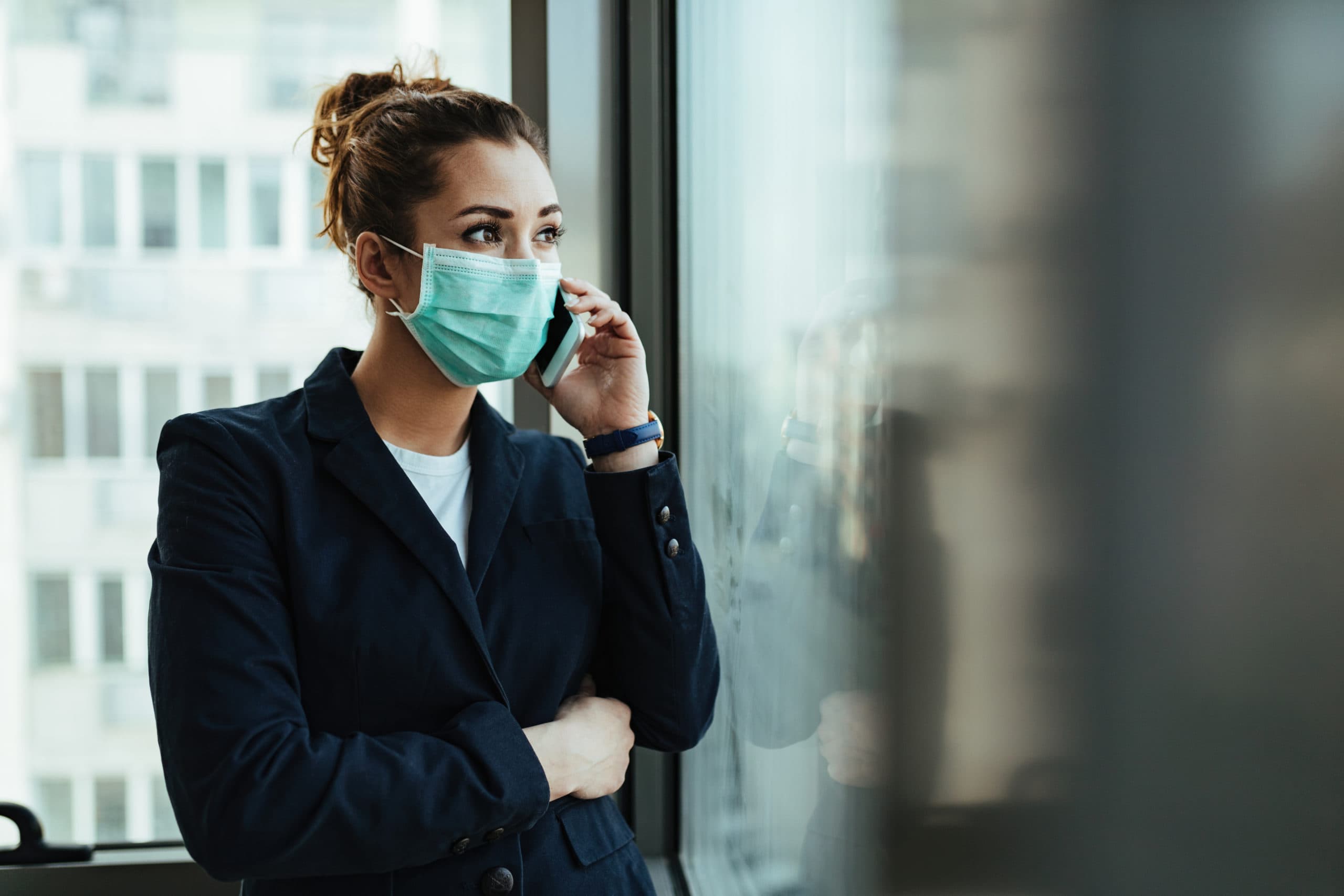 Remote B2B calling during COVID-19 pandemic Businesswoman wearing mask making remote B2B call during COVID-19.