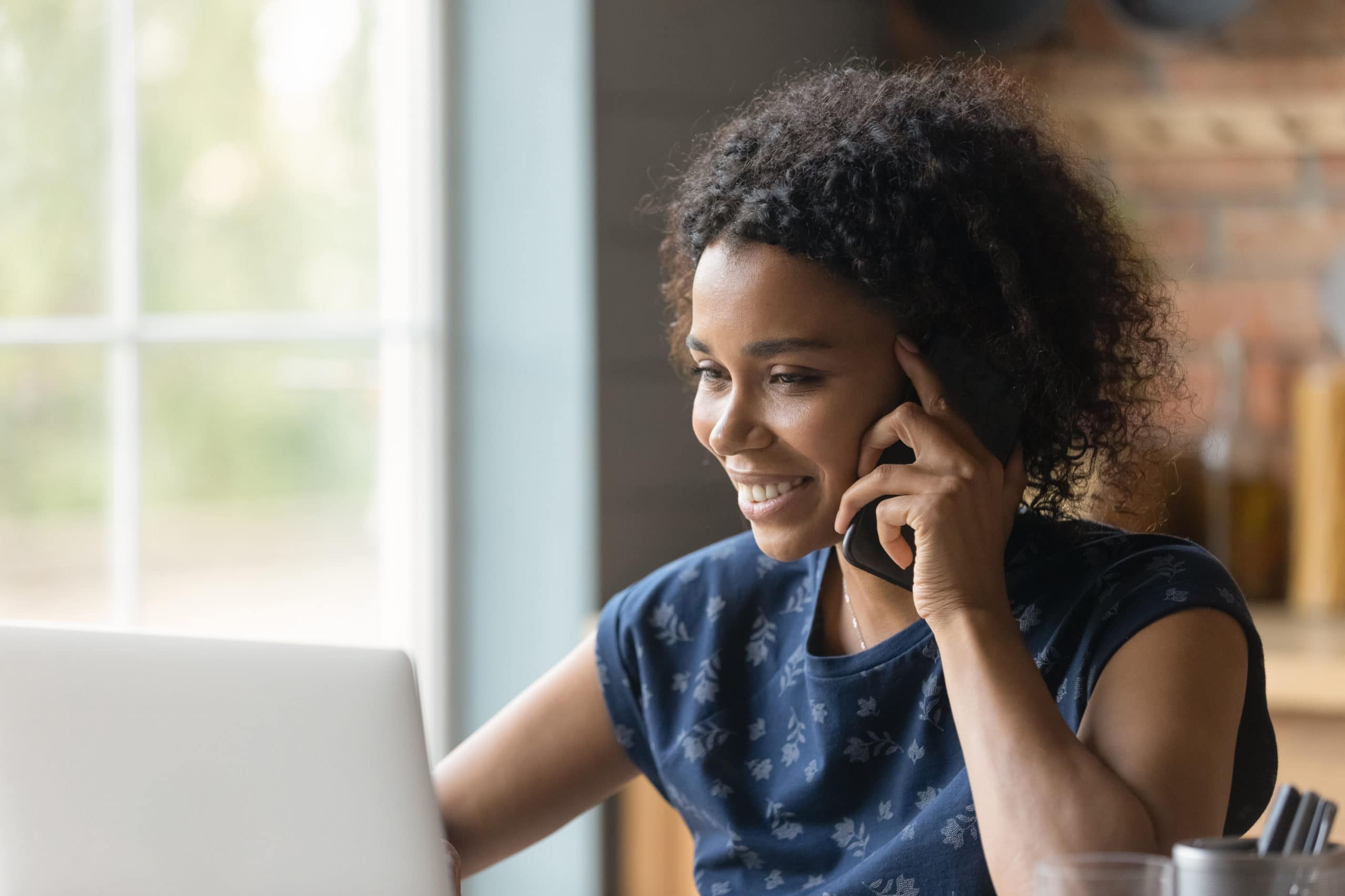 Boost Your Business with Lead Nurturing Strategies Woman on phone working on laptop, promoting lead nurturing for business growth.