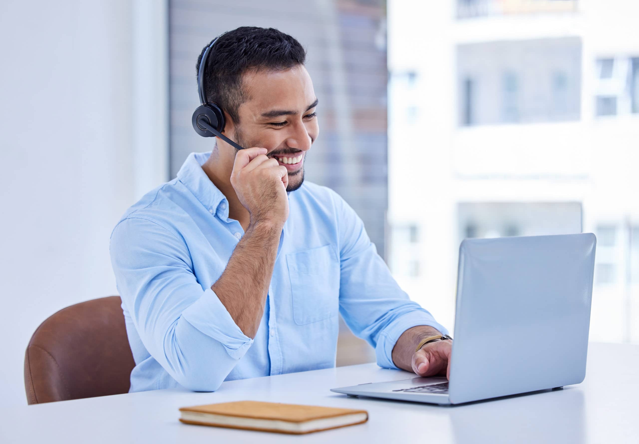 Sales enablement for healthcare professionals Healthcare sales enablement professional using headset with laptop.