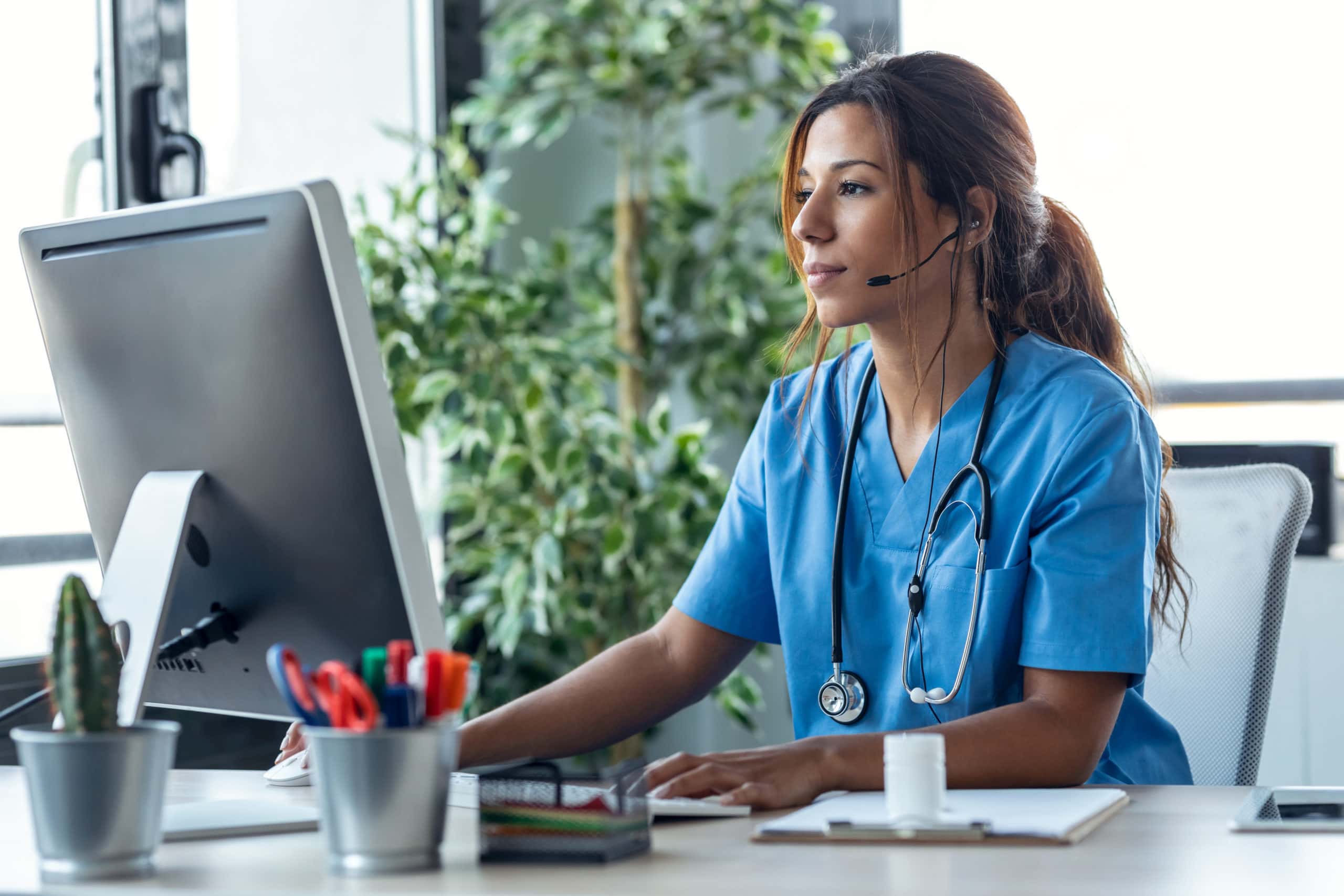 Medical professional working on a computer in a healthcare setting. Medical professional using a computer for medtech sales lead generation.