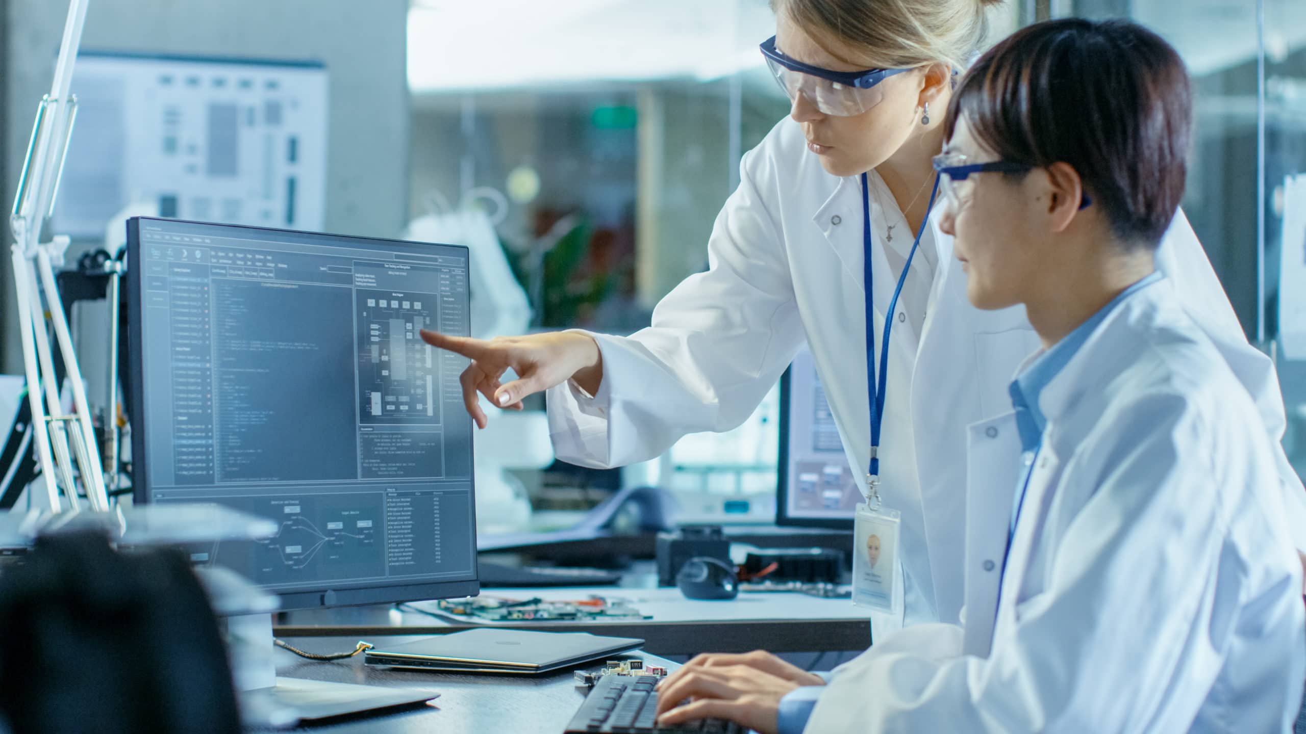 Maximize Customer Revenue Opportunities Two scientists analyzing data on a computer screen in a laboratory setting.