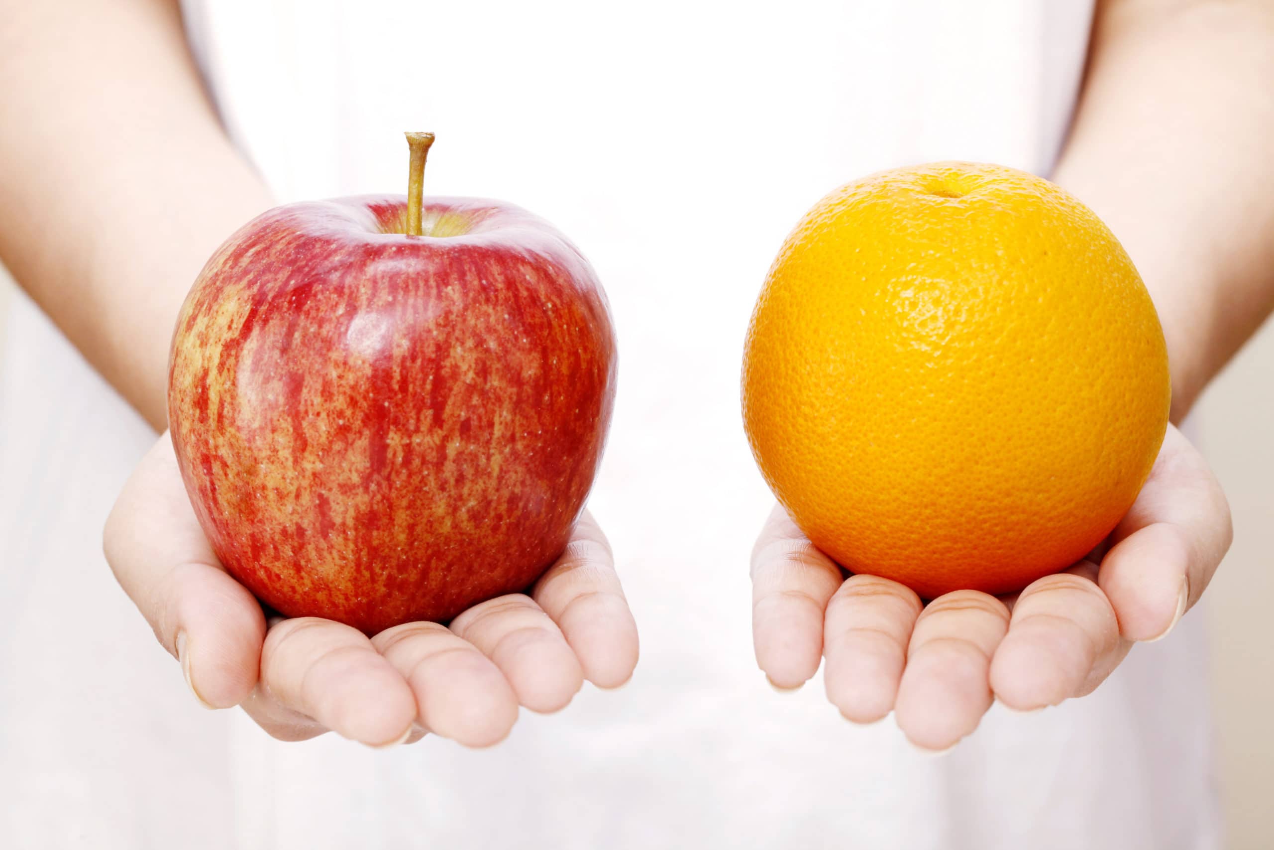 Apple and orange in hands for healthy eating. Apple and orange held in hands, symbolizing healthy choices and fresh fruit.