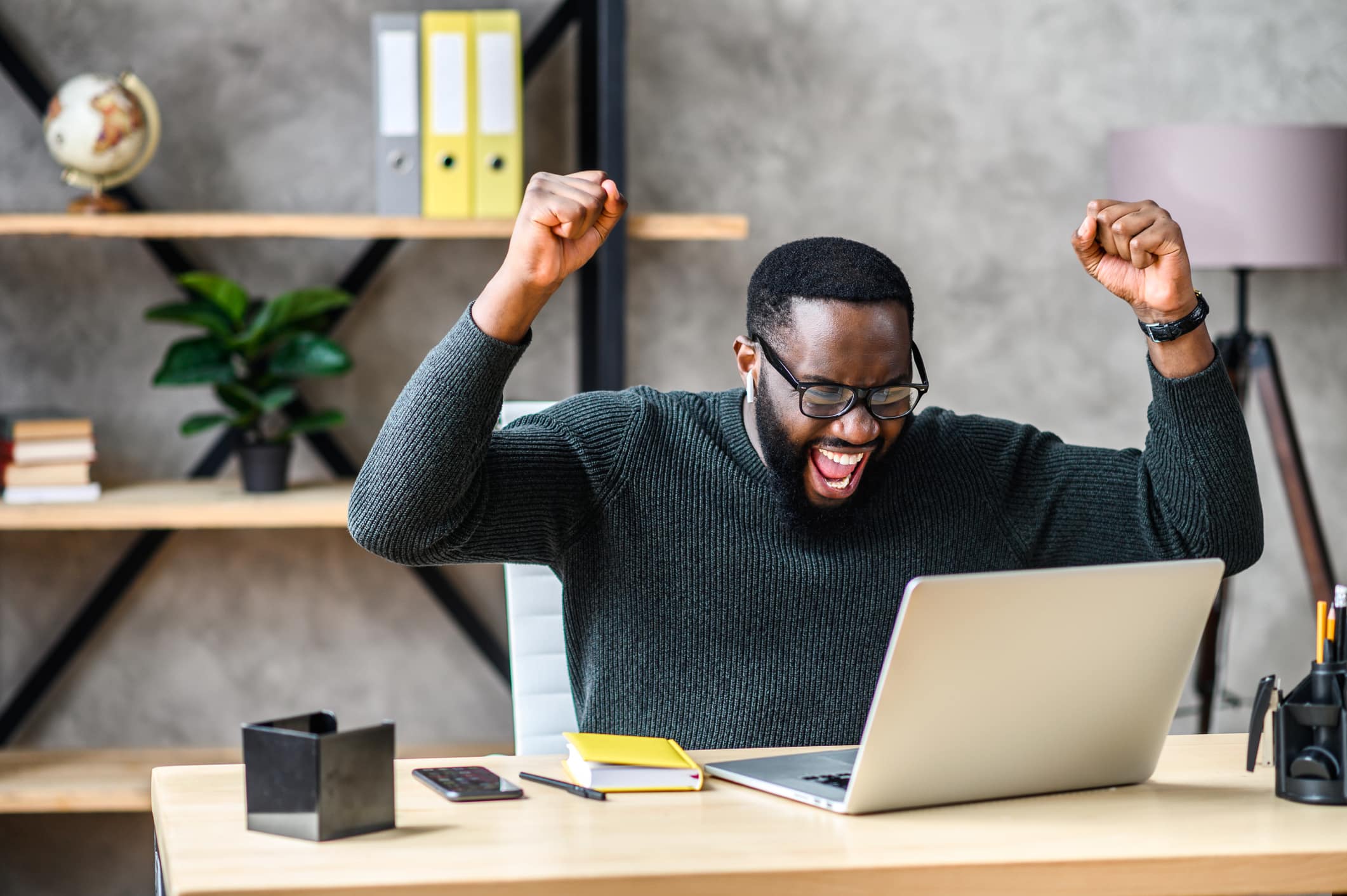 Motivated Remote Sales Team Enthusiastic man celebrating success with remote sales team at home office.