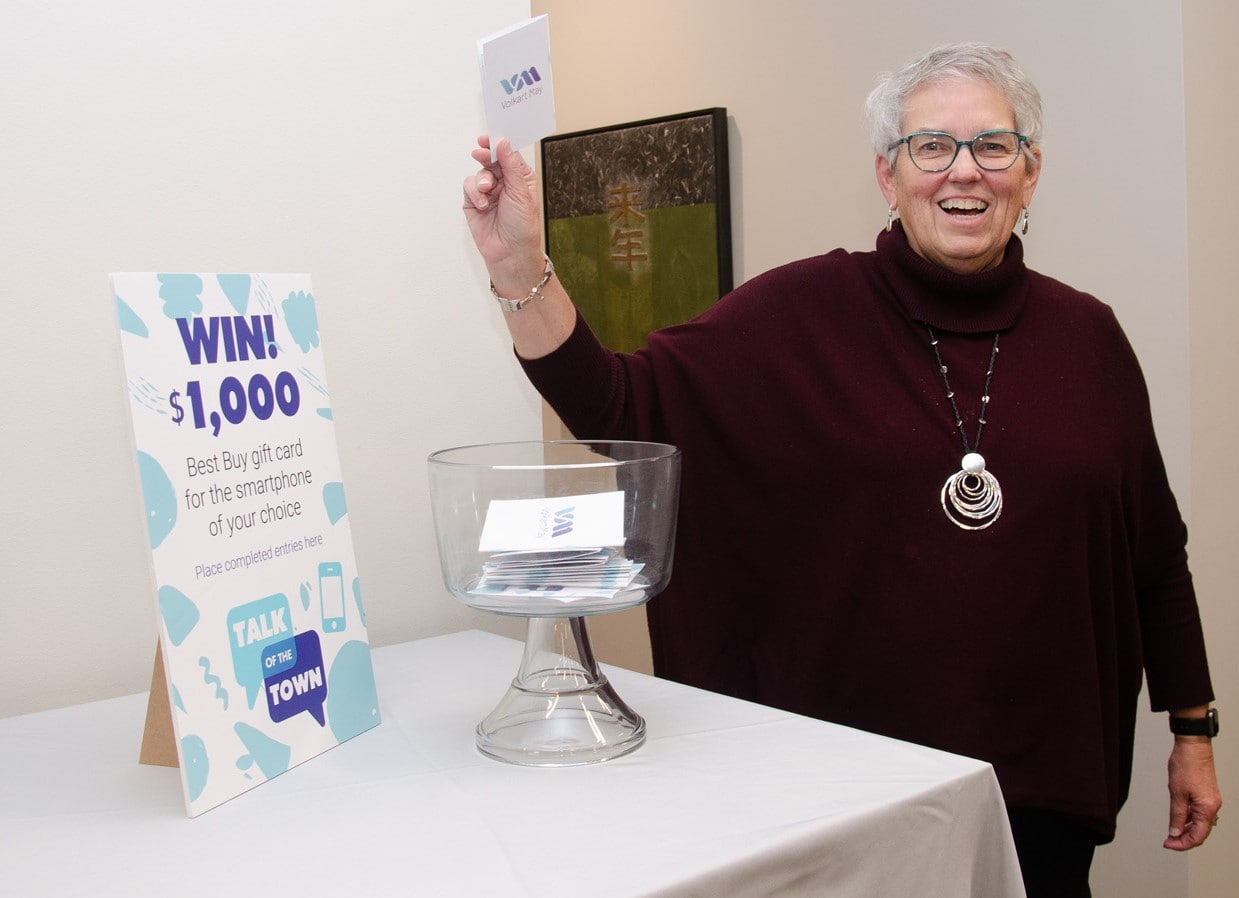 Volkart May Call Center Tour Woman celebrating at call center with prize draw sign.