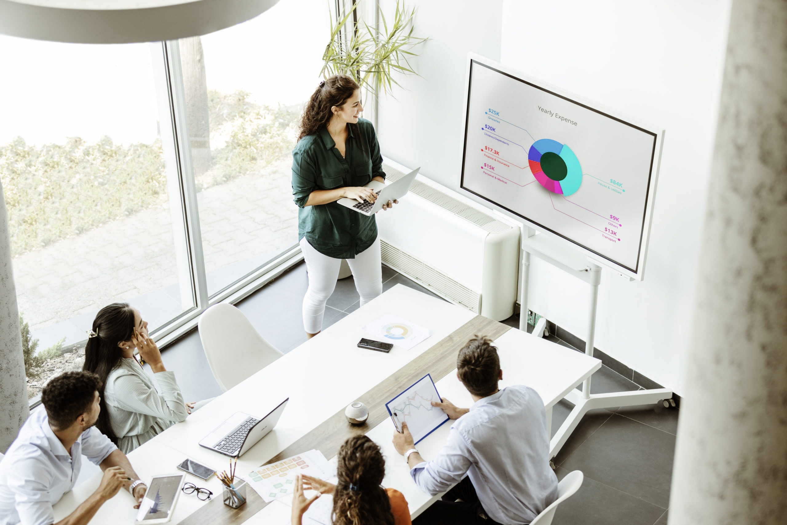Effective Lead Generation Strategies for Business Growth Businesswoman presenting data on lead generation and metrics to team in modern conference room.
