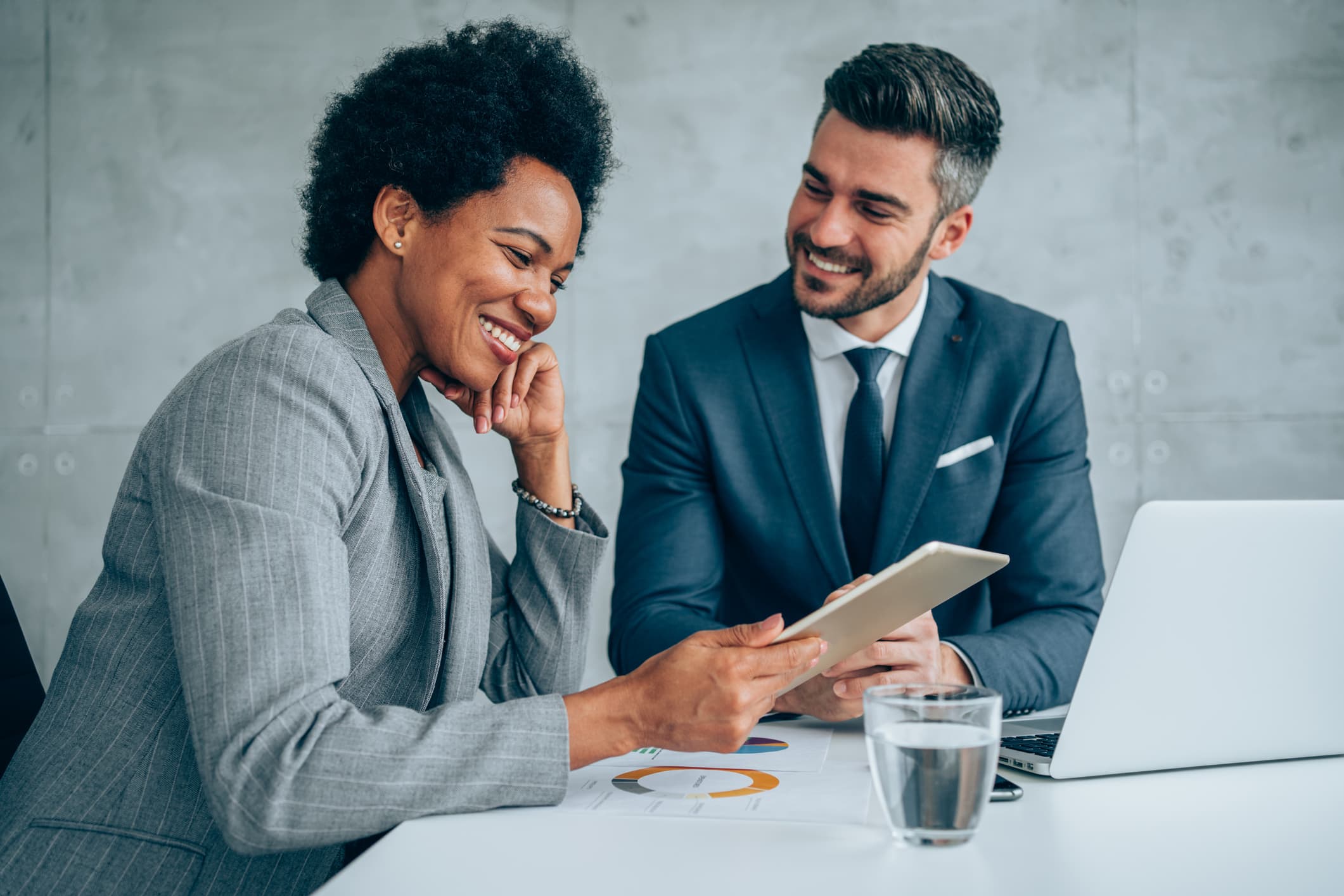 Boost Your Sales Appointments Business professionals discussing sales strategies with tablet and laptop.