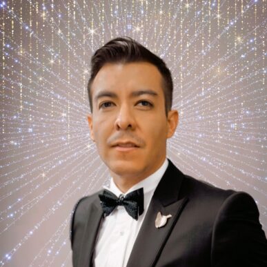 Final Profile Pic (square) A man in a tuxedo and bow tie stands in front of a sparkling background with radiating lines and twinkling lights, creating a glamorous, starburst effect behind him.