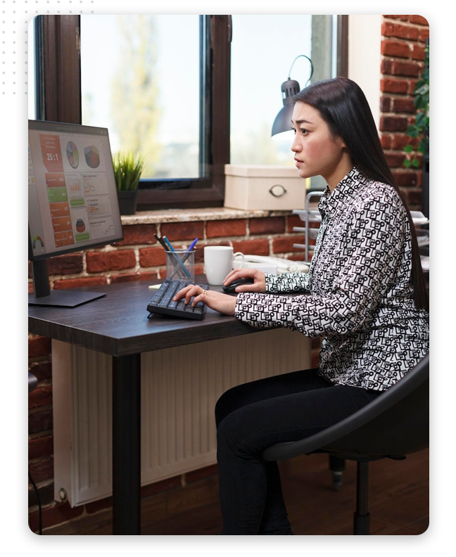 content-marketing-process-img A content marketing specialist sits at a desk in a modern office with exposed brick walls and a large window, focusing on charts displayed on the monitor.