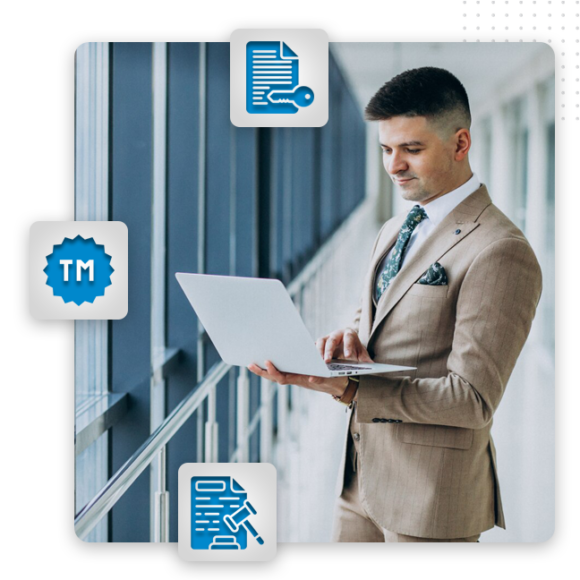 graphic-design-Complete-Ownership-img A man in a tan suit stands in a modern hallway using a laptop. Surrounding him, three blue icons symbolize legal and trademark concepts—essential elements for a graphic artist providing brand design or graphic design services.